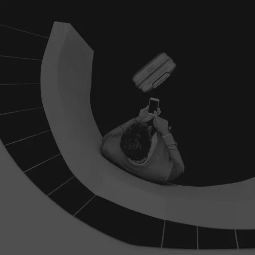 Businessman with smartphon standing at staircase